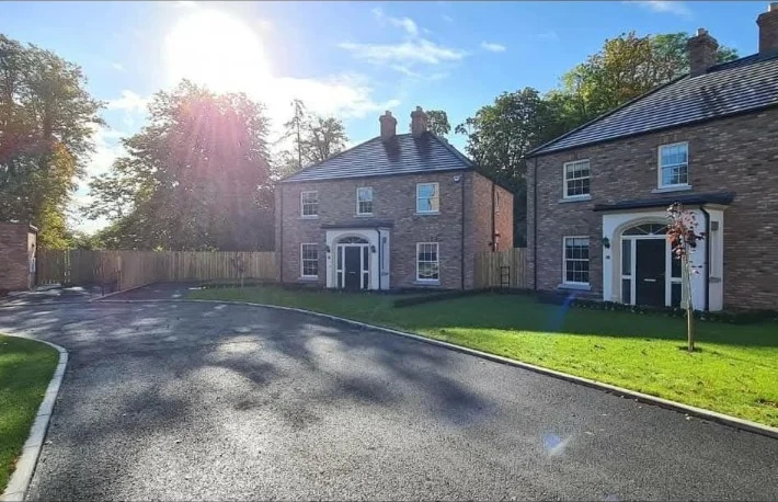 Finished road and landscaped spaces beside brick homes